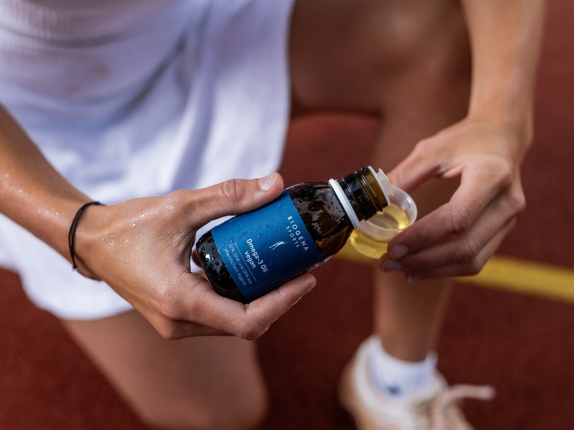 Il tennista versa una dose di BIOGENA SPORTS - Vegan Omega-3 Oil nel misurino.