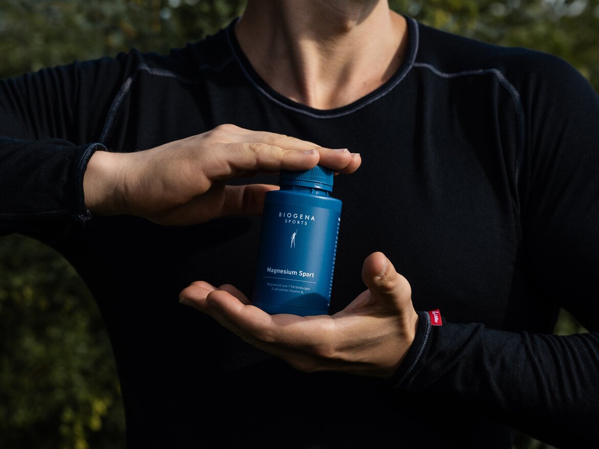 Magneziul B6 Sport de la Biogena este ținut în ambele mâini de o sportivă.