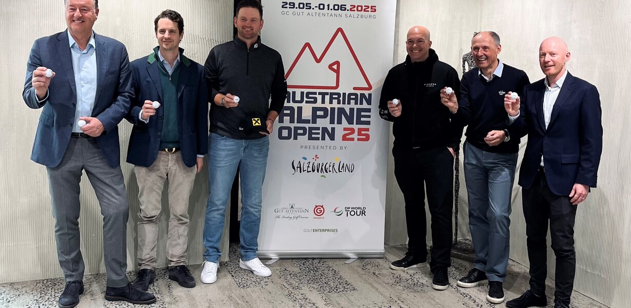 6 Männer die Golfbälle in der Hand halten, neben einem Aufsteller der Austrian Alpine Open 25