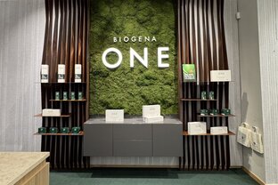 Moderne Kasse in einem Store, mit Graswand und BIOGENA ONE in leuchtender Schrift