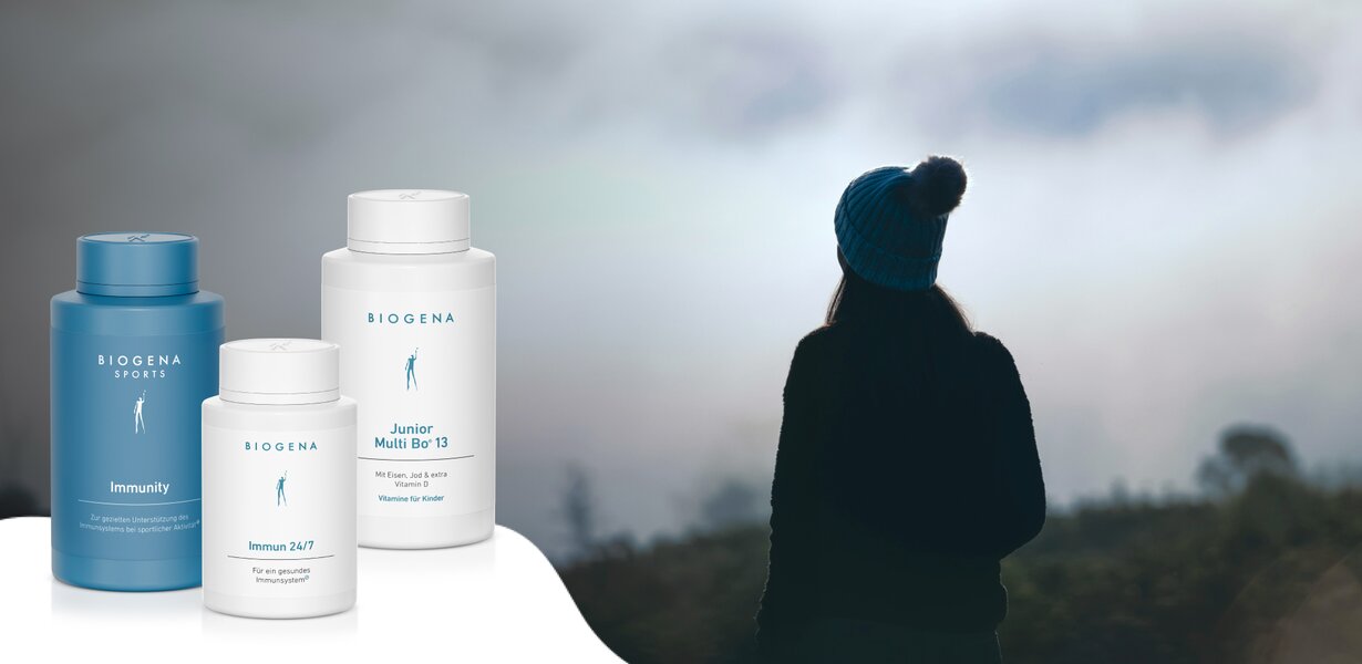 Ein Bild, das drei Biogena-Produkte zeigt: Biogena Sports Immunity, Biogena Immun 24/7 und Biogena Junior Multi Bo°13. Im Hintergrund ist eine Person mit einer blauen Mütze in der Natur zu sehen.