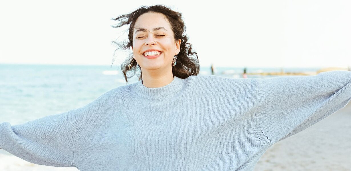 Femme au grand sourire sur la plage