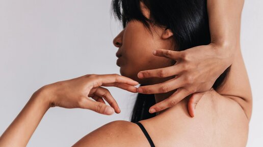 Frau mit schwarzen Haaren und glatter Haut mit ihren Händen an ihrem Kopf