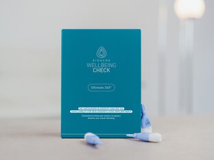 Nahaufnahme eines BIOGENA Wellbeing Check Kits mit blauen Lanzetten und Informationskarte auf hellem Untergrund.