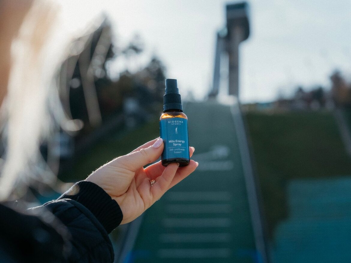 Osoba koja drži Mito Energy Spray u prvom planu, sa skakaonicom u pozadini